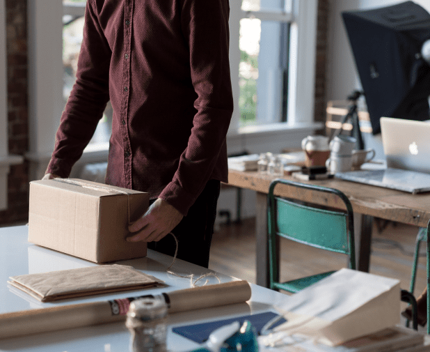 Ein Mann verpackt ein Paket für einen E-Commerce-Shop.